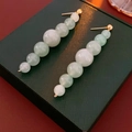 Dettaglio di orecchini a pendente con pietre di avventurina verde chiaro e oro - Perline Verdi (Ago in Argento S925)