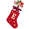 Detail of red Christmas stocking with golden sequin letter E and festive fillers - Red E