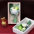 Detailed view of soap rose flower gift boxes in pink and white with decorative ribbons - Malachite green