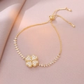 Detailed view of rotating golden clover charm with sparkling zircons and adjustable slider - Gold Bracelet / Gold