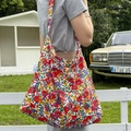 Grande borsa a tracolla in tela a fiori indossata da una modella in un set esterno - Floreale Primaverile