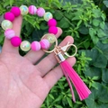 Vibrant silicone bead keychain bracelet with PU tassel and marble prints on wrist - Rose Red
