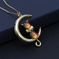 Elegante collana con pendente luna dorata e gatto arcobaleno su una scatola di gioielli - Arancione