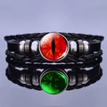 Close-up of leather bracelet with red dragon eye gemstone on reflective surface - Red Cat Eye Style