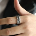 Macro detail of silver vintage Viking ring with geometric triangle hollowed out patterns - Steel / US 7