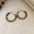Detalle de pendientes redondos de leopardo con toques dorados sobre fieltro beige - Marrón - 3cm