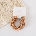 Detail of champagne gold pearl beaded hair tie on white handmade card packaging - Card Packaging / Champagne