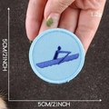 Round blue embroidered scout patch featuring a rowing athlete, 5cm diameter size - Pale Blue Rowing