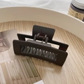 Matte brown oversized rectangle hair claw clip displayed on a wooden tray for styling - Matte Dark Grey Hollow Hair Claw