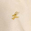 Detailed view of a gold-plated letter Y stainless steel pendant on silk fabric - Letter-Y