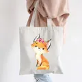 Off-white canvas tote bag featuring a cute floral fox print, shown as a shoulder bag - Style C10-Fox Wearing Wreath