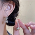 Close-up of silver knot and polished metal ball earring on a model ear - Silver Knot Ball Studs