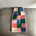 Flat lay of colorful patchwork knitted tote bag with blue pink and green squares - Pink Large Checkerboard