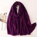 Detalle de bufanda morado oscuro efecto lino con flecos finos y fondo minimalista - Violeta
