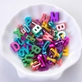Close-up of colorful metallic alphabet beads in a shell-shaped bowl for DIY jewelry - Colorful Metallic Gloss Mixed Perforated Letters