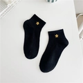 Close-up of black cotton ankle socks featuring delicate gold star embroidery detailing - Black - Yellow Star