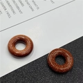 Macro view of polished brown goldstone donut beads with shimmering gold specks - Synthetic Goldstone