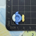 Detailed macro view of an 1.8cm blue and white fish resin charm on a scale ruler - Fish Shaped Swim Ring