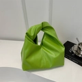 Minimalistische heldergroene PU-lederen draagtas met geknoopte handgreep op witte standaard - Groen