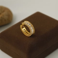 Detalle macro de anillo dorado de lujo con gemas rectangulares sobre terciopelo - Dorado