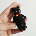 Handmade black crochet cat keychain with red collar and golden bell on a white background - Pure Black Cat