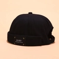 Classic black cotton docker hat featuring a vintage brimless design and side fabric label - Peeping Label Black