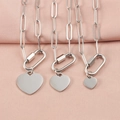 Three silver heart pendant necklaces with carabiner clasps on pink fabric background - 10mm / Steel