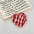 Close-up of a red and white checkered fabric heart charm with a rustic frayed edge - Red and White Checkered Heart