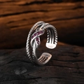 Macro detail of 925 silver twist ring with a red gemstone on a vintage wood surface - Adjustable Open / Red Zirconia