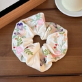 Cremefarbenes Satin-Haargummi mit farbenfroher Blumenbestickung auf einer Holzoberfläche - Weiße Blumenstickerei