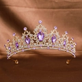 Luxurious gold bridal crown with purple teardrop gems and small diamonds on brown fabric - Gold Purple