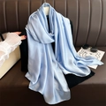 Detail of light blue satin scarf draped over leather sofa with aesthetic accessories - Sky Blue