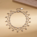 Dettaglio di collana a più fili con perline argentate e ciondoli sfaccettati - Bracciale / Argento