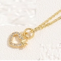 Nahaufnahme der goldenen Halskette mit funkelndem Herzanhänger und kleiner Krone oben - Kronenherz / 14K Gold