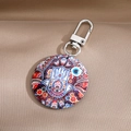 Detail of bohemian mandala keychain with evil eye charm on beige velvet background - Red Colorful Evil Eye Pattern