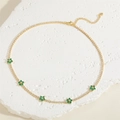 Close-up of golden floral choker with green zircon petals and adjustable lobster clasp - Green