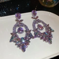 Gros plan de boucles d'oreilles vintage avec cristaux violets et roses sur plat blanc - Grand / Violet