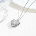 Detail shot of a silver hollow heart pendant with hammered texture on a white surface - Hammered Heart Pendant Necklace / Silver