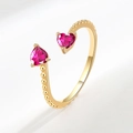 Adjustable golden ring featuring two pink heart-shaped stones and beaded band detail - July (Rose Red)