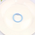 Sky blue elastic hair tie with rectangular decorative buckle on white ceramic plate - Blue