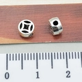 Silver Tibetan beads with hollow ancient coin patterns shown with a measurement ruler - Hollow Diamond Spacer Bead