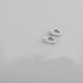 Macro view of silver snake earrings with detailed metal scales and green gemstone eyes - Platinum (Green Eyes)