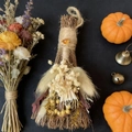 Close-up of a rustic decorative broom with white dried flowers and amber gemstone on black - Broom+Flowers+Red Agate