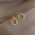 Detailed macro of gold ring earrings with white pearls, zircons and tiny ribbon bow - A066 Gold Simple Ribbon Bow Pearl Stud Earrings