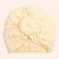 Detail of cream baby turban hat showing bubble waffle texture and donut knot decoration - Beige
