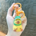 Porte-clés Capybara jaune mignon avec un chapeau de dinosaure vert en caoutchouc souple - Capybara en Résine-Style Dinosaure