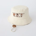 Dettaglio del ricamo dell'orso e del cordino regolabile sul cappello a secchiello beige - 50cm / Bianco Sporco