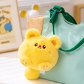 Porte-clés peluche animal jaune rond avec détails de pattes roses sur un sac en toile vert - Ours au Beurre