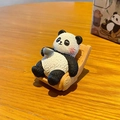 Cute panda figurine resting on a wooden rocking chair holding a tiny tea cup - Brewing Tea / Color Box