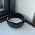 Detail view of glossy black wide resin bangle with a polished geometric mirror finish - Black